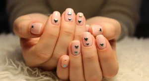 Chrome heart nail design on soft nude base