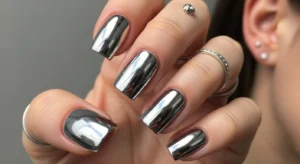 Short silver chrome nails with mirror shine on a neutral background