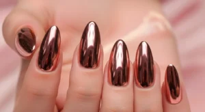 Rose gold chrome nails with warm metallic shine on almond shape