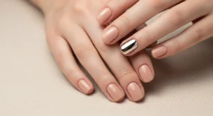 Minimal nude nails with single chrome accent nail design