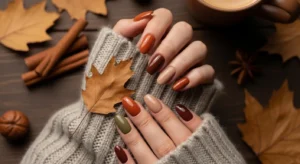 Cozy Thanksgiving nail ideas in warm fall colors like brown, orange, and nude tones
