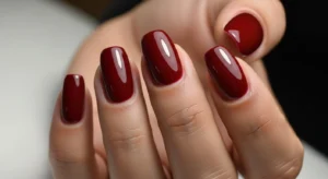 Dark cherry nails on dark skin with rich glossy finish