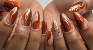 Abstract fall nail art on dark skin with brown and orange tones