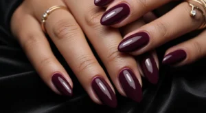Plum purple fall nails on dark skin with glossy finish