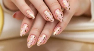Short pale pink nails decorated with gold foil details
