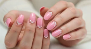 Short pink nails with small pearl nail accents
