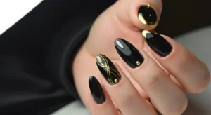 black nails with gold accent details, bold elegant manicure, glossy finish