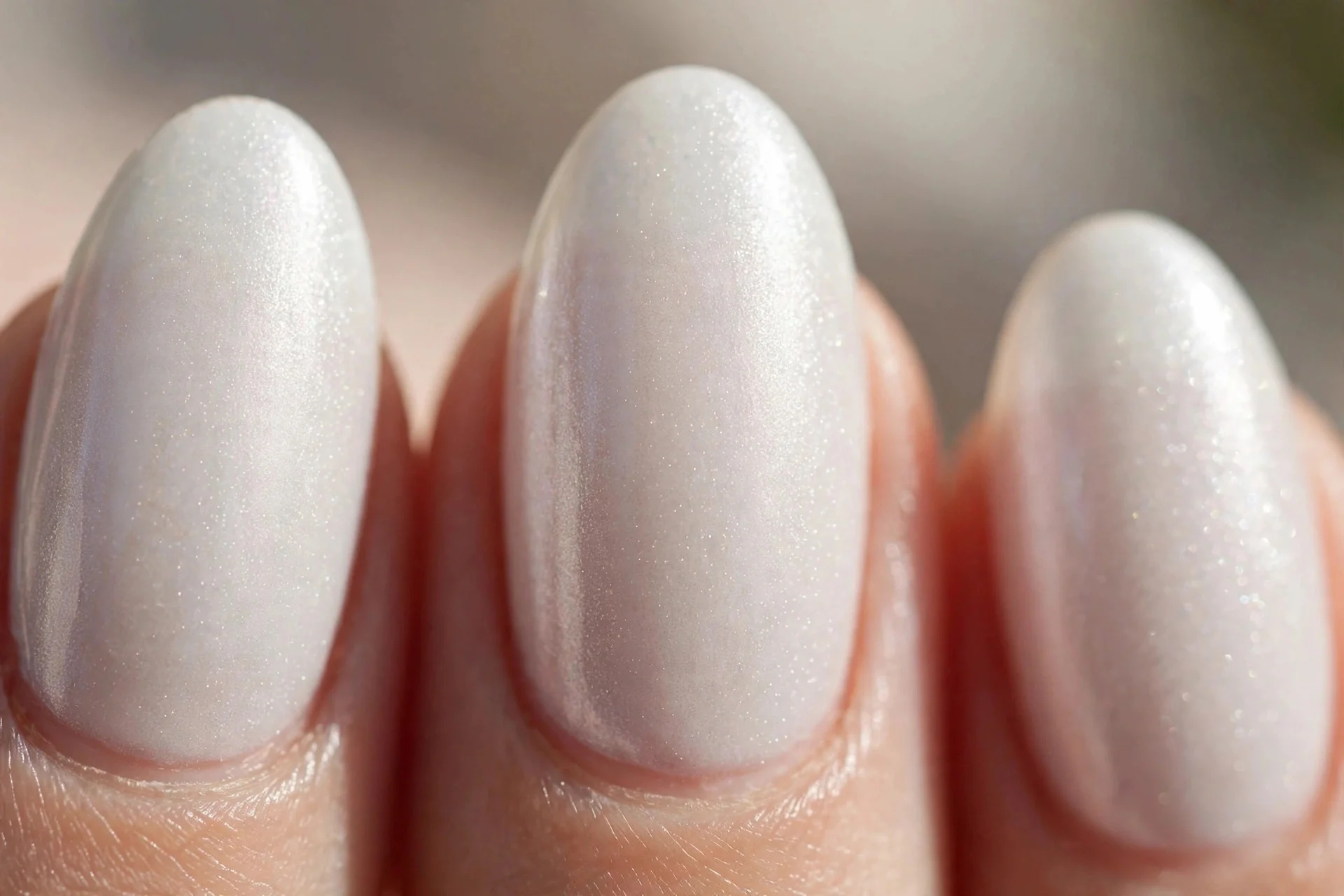 Almond nails in pearl white polish with a soft luminous shimmer