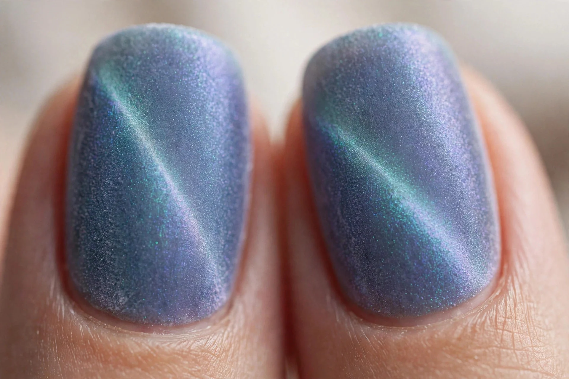 Extreme macro of two fingernails in aurora cat-eye gel under a matte top coat, crushed velvet diffused glow, soft light