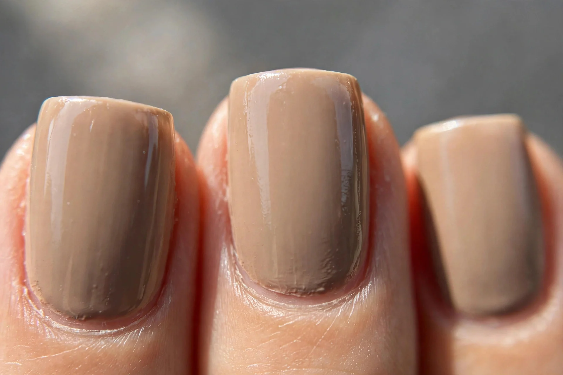 Warm greige cr&egrave;me polish on medium square nails, glossy, grey background