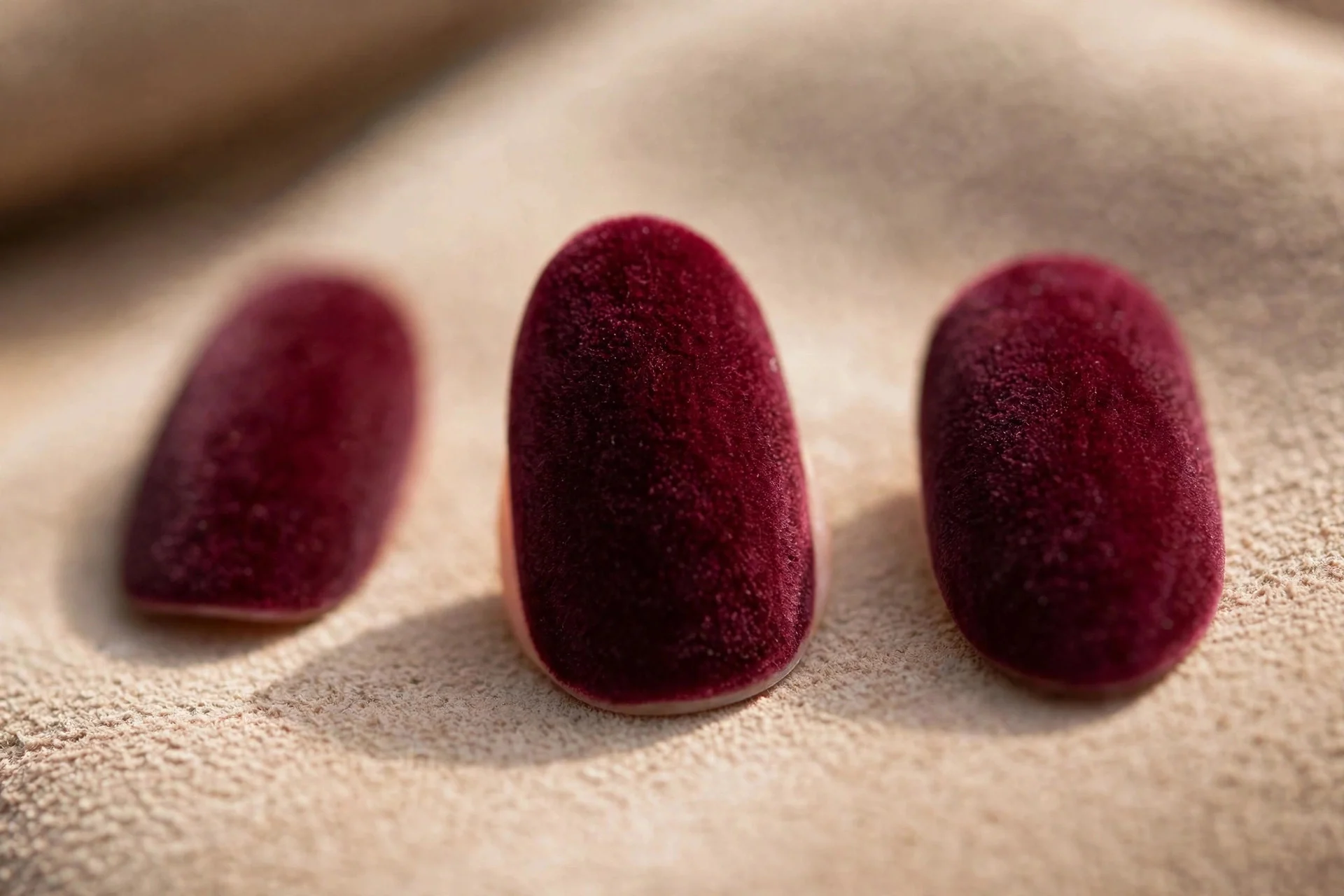 Burgundy polish with velvet textured finish, almond nails