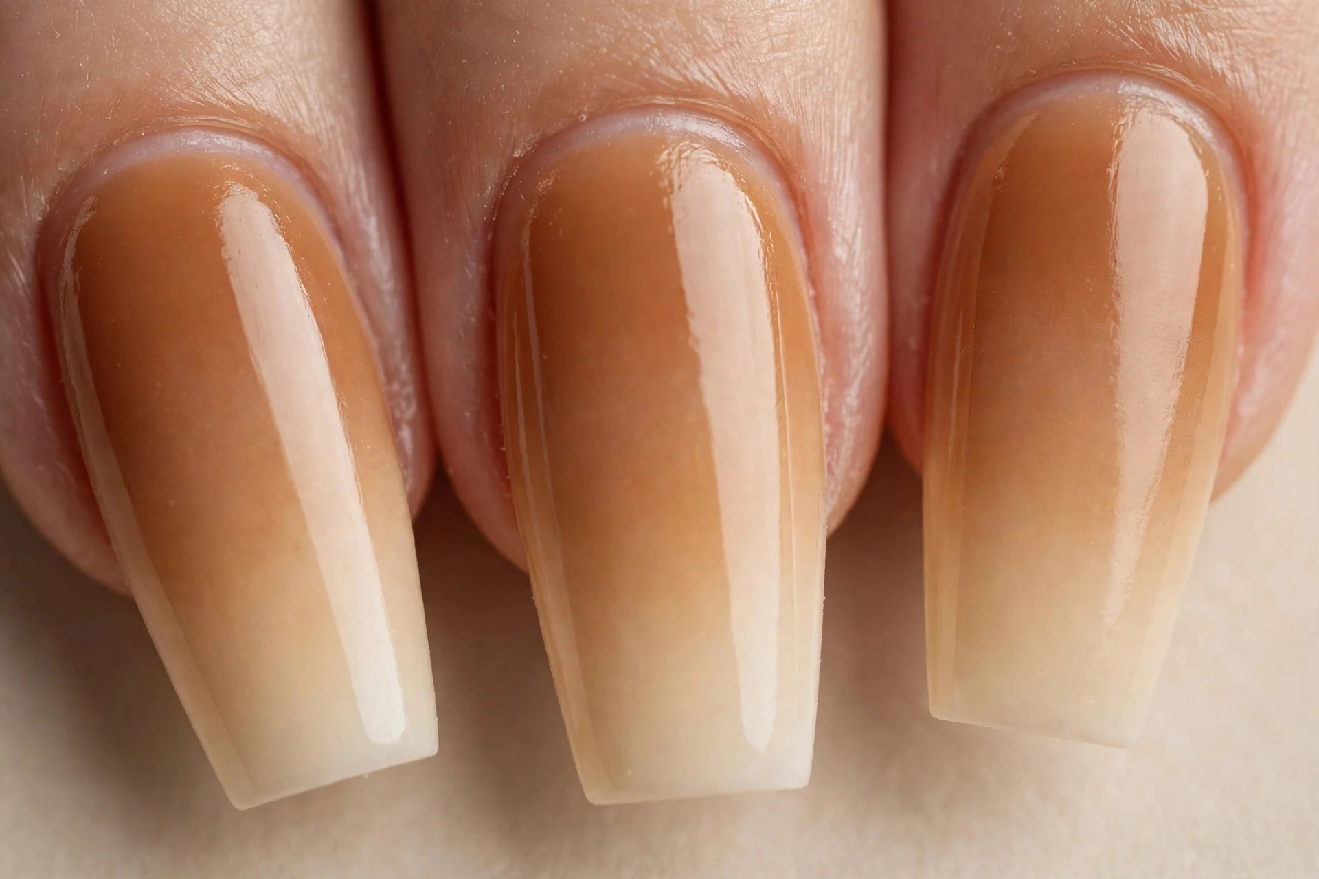 Coffin nails with caramel-to-cream ombr&eacute;, beige background