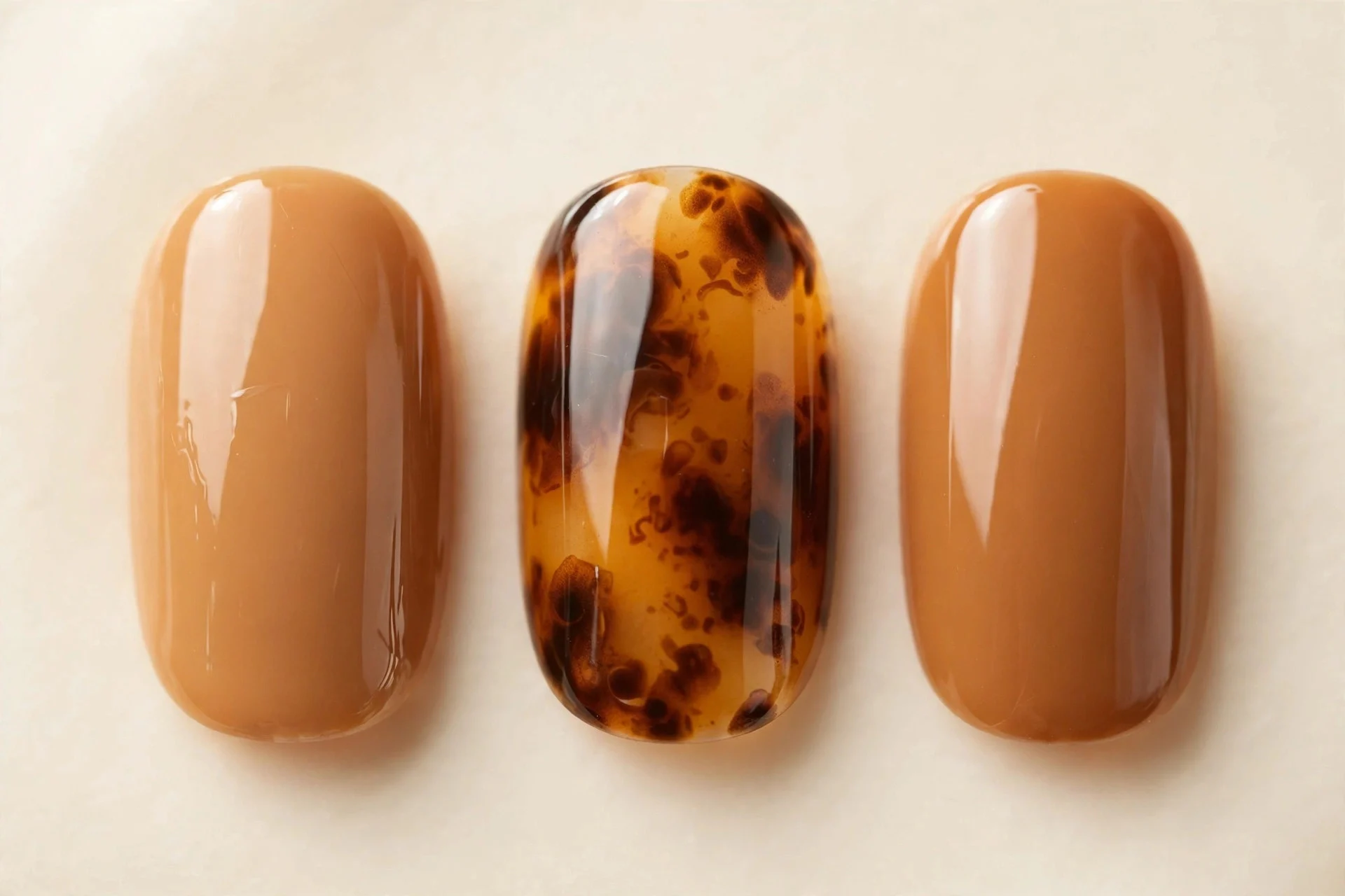 Caramel nails with tortoiseshell amber-brown accent nails, cream background