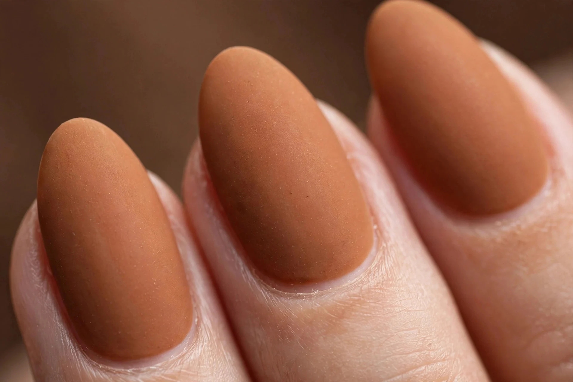 Almond nails in matte spiced caramel, soft brown background