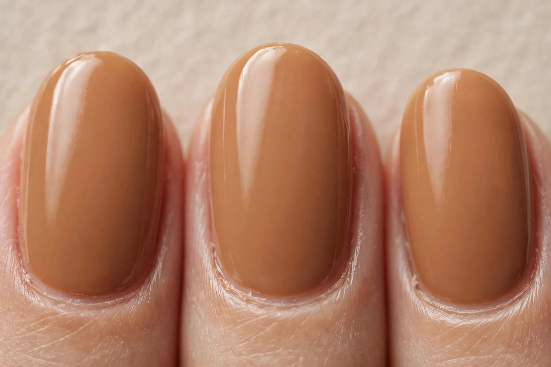 Oval nails in balanced medium caramel cr&egrave;me gel, beige background