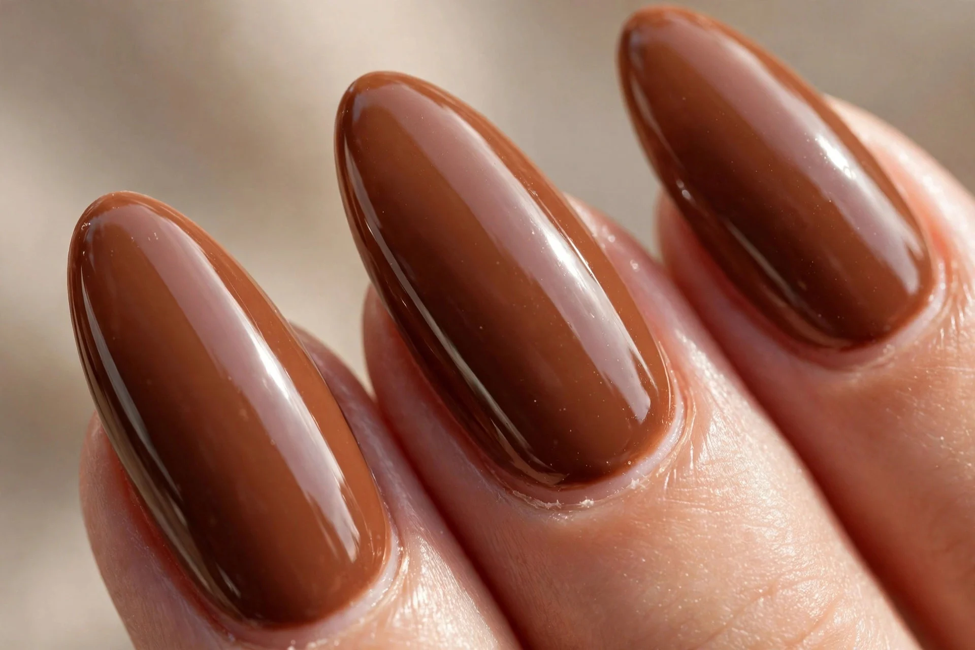 Long almond nails in rich toffee brown with high-gloss topcoat.