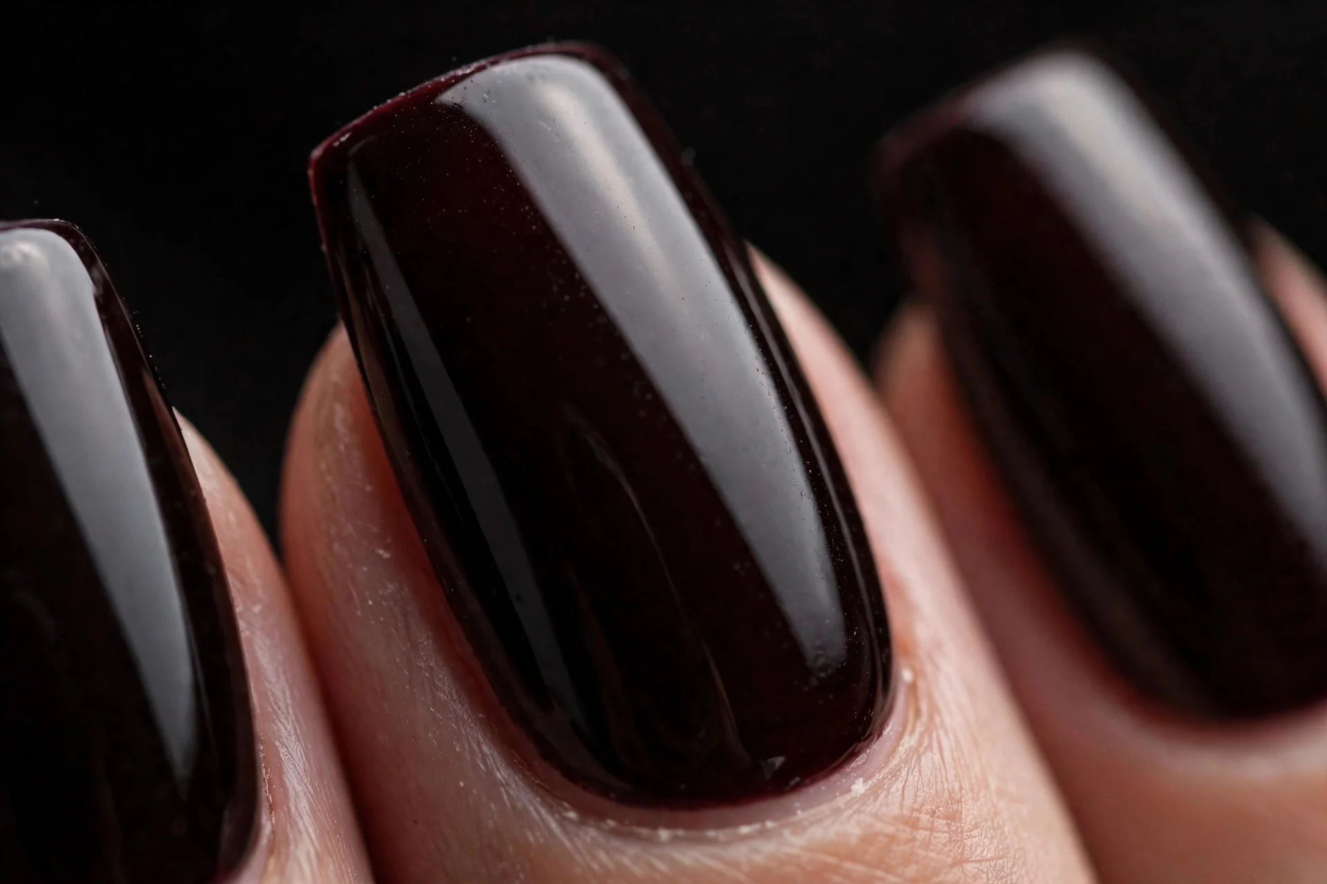 Coffin nails in near-black cherry crème, glossy, dark background