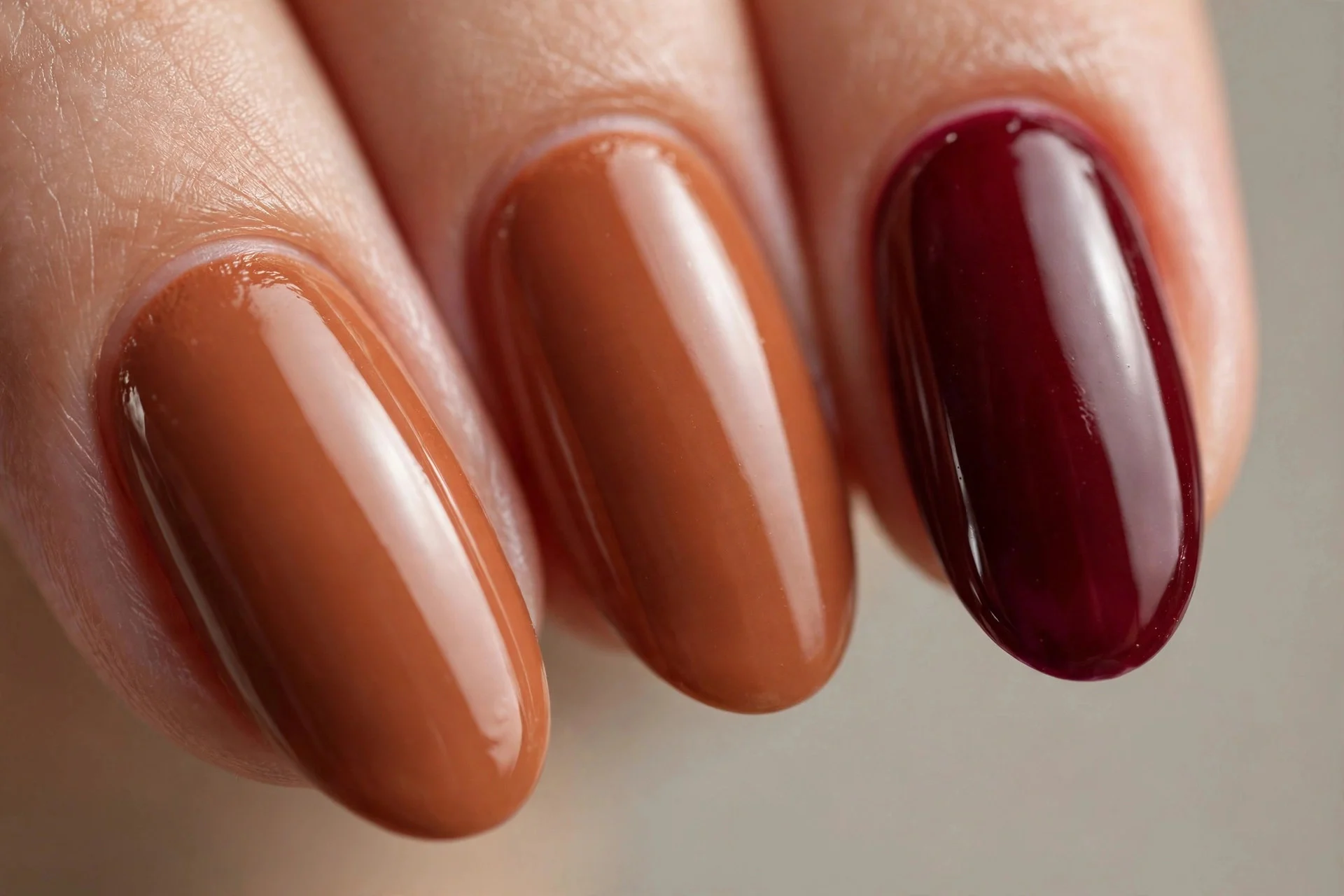 Almond nails, cinnamon base with deep cranberry accent nails, glossy, neutral background