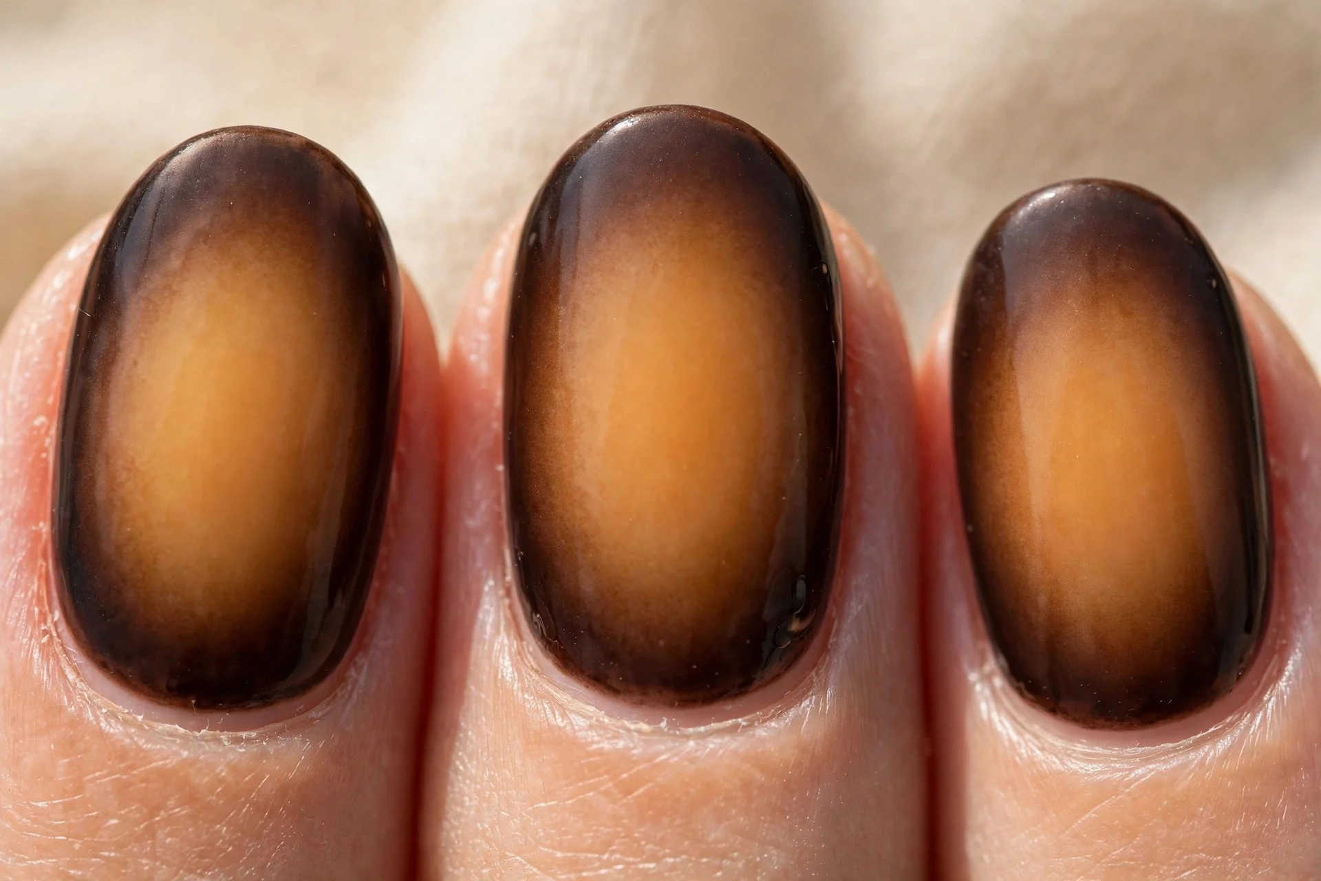 oval nails with dark brown aura effect fading to caramel center