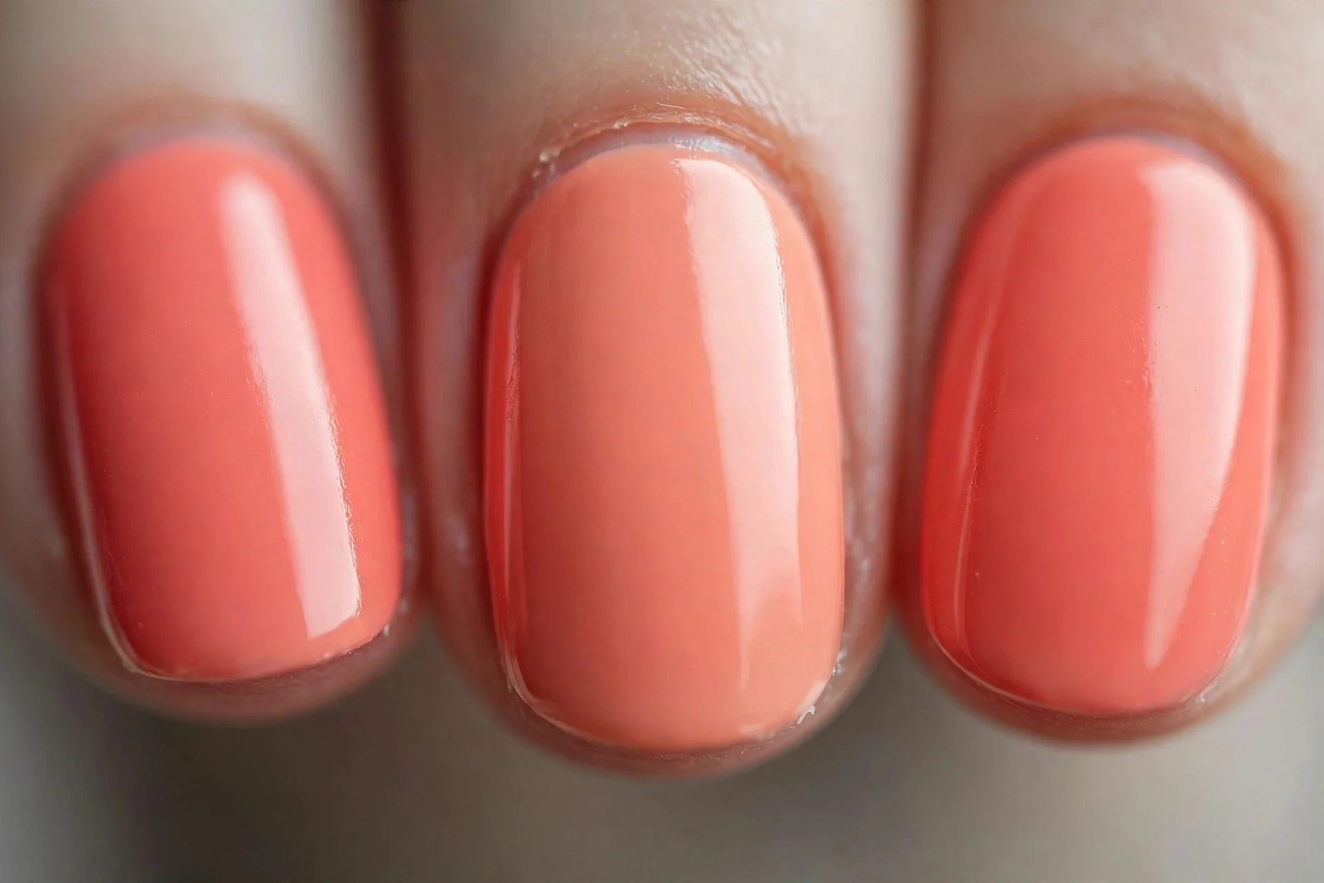 True coral pink-orange cream polish, short oval nails, high gloss