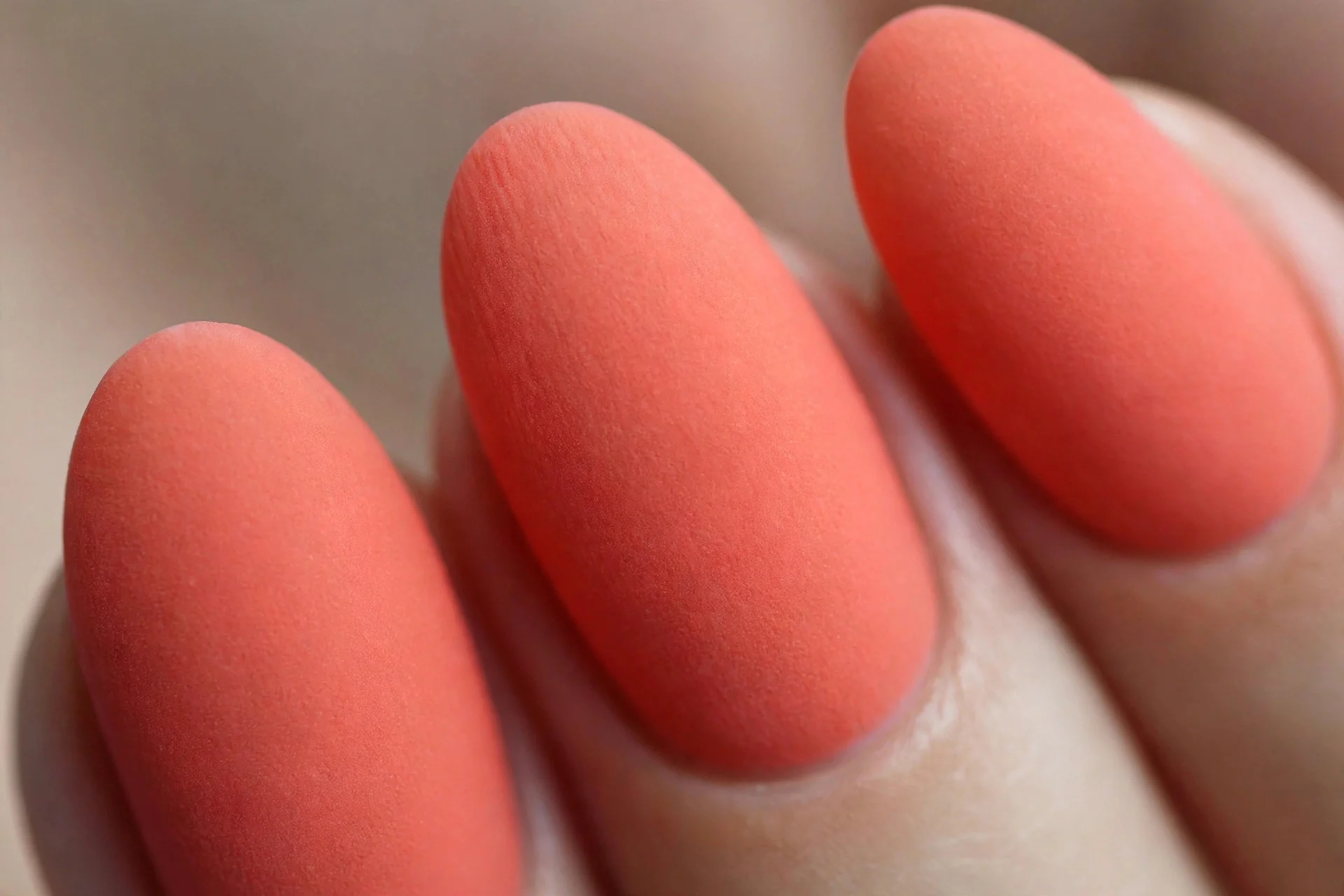 True coral polish with velvet matte finish, medium almond nails