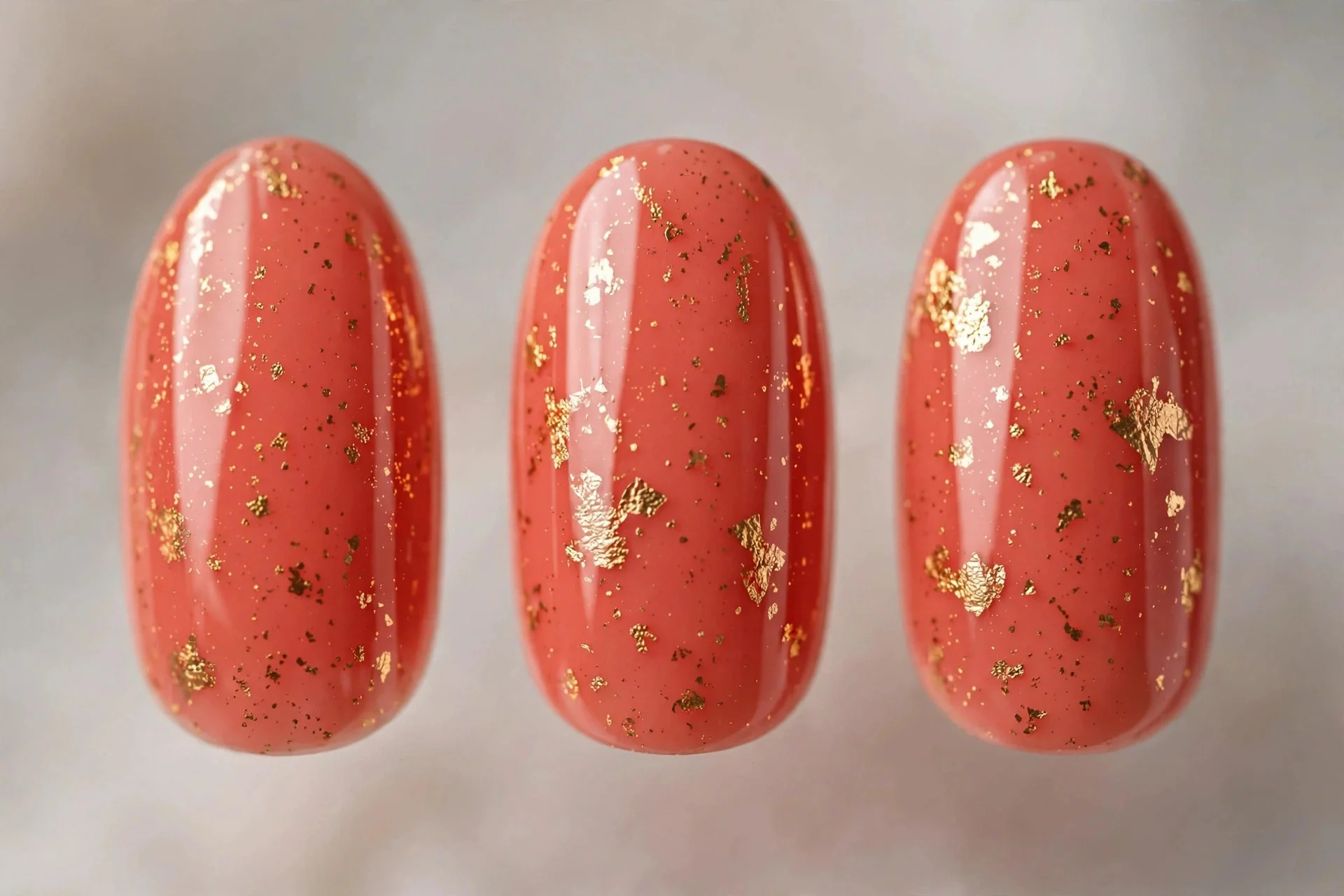 Coral nails with gold foil flakes, medium almond, glossy