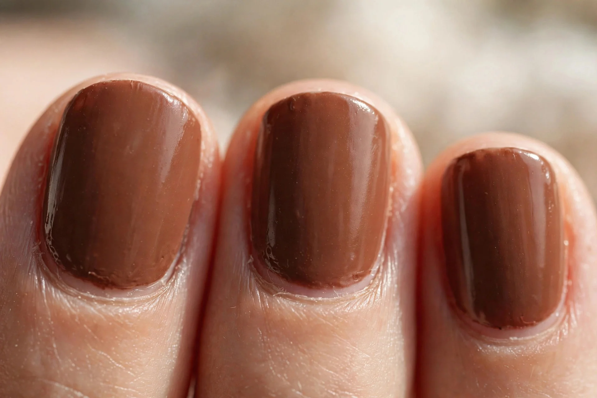 short rounded nails in warm cocoa brown polish