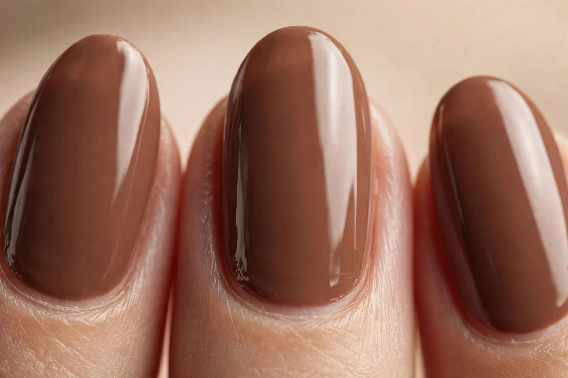 Almond nails in creamy milk-chocolate brown gel, warm neutral background