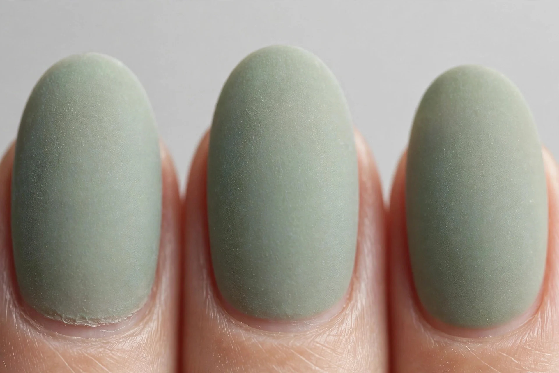 Oval nails in frosted sage green gel, light grey background