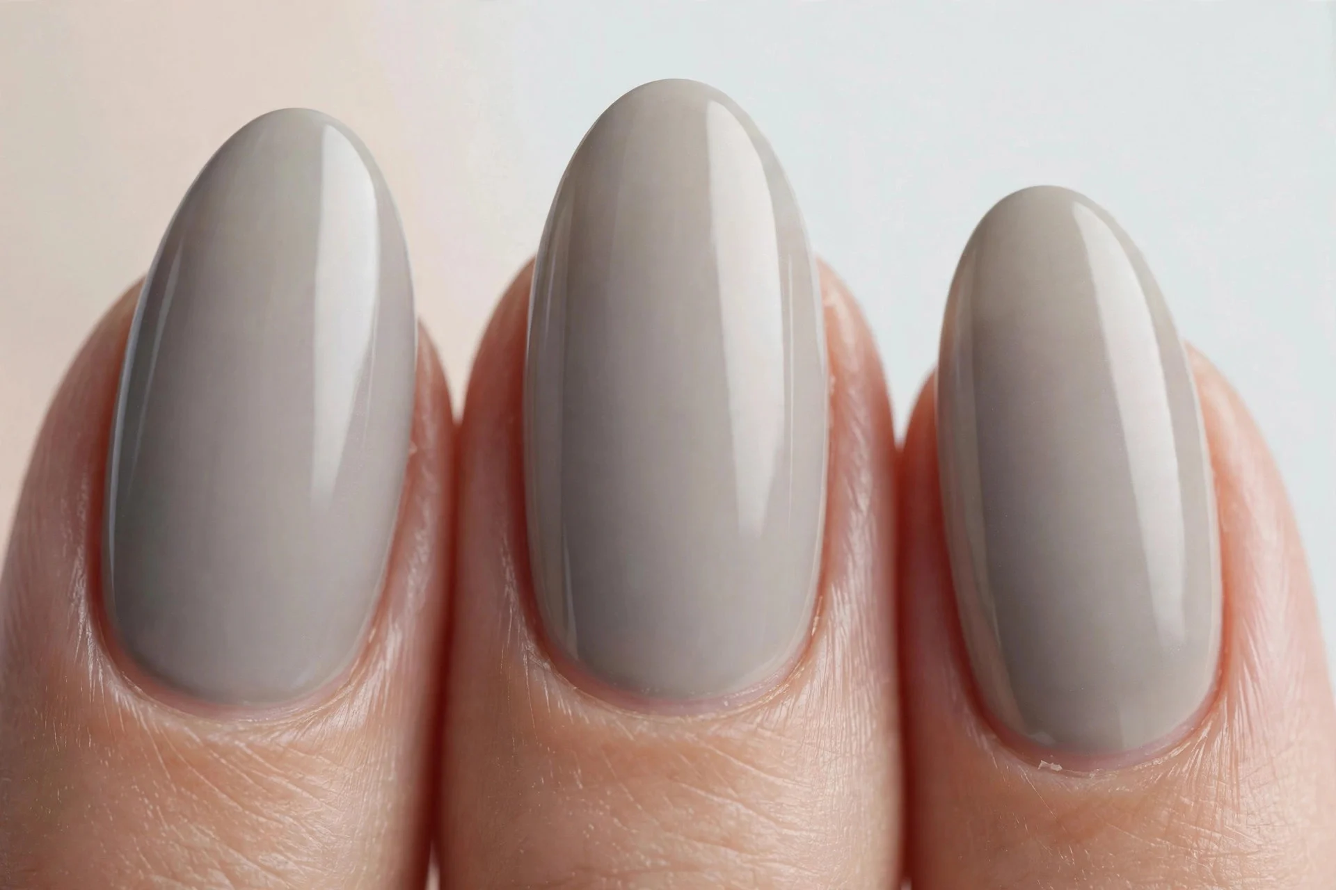 Almond nails in cool grey-toned greige polish, light background