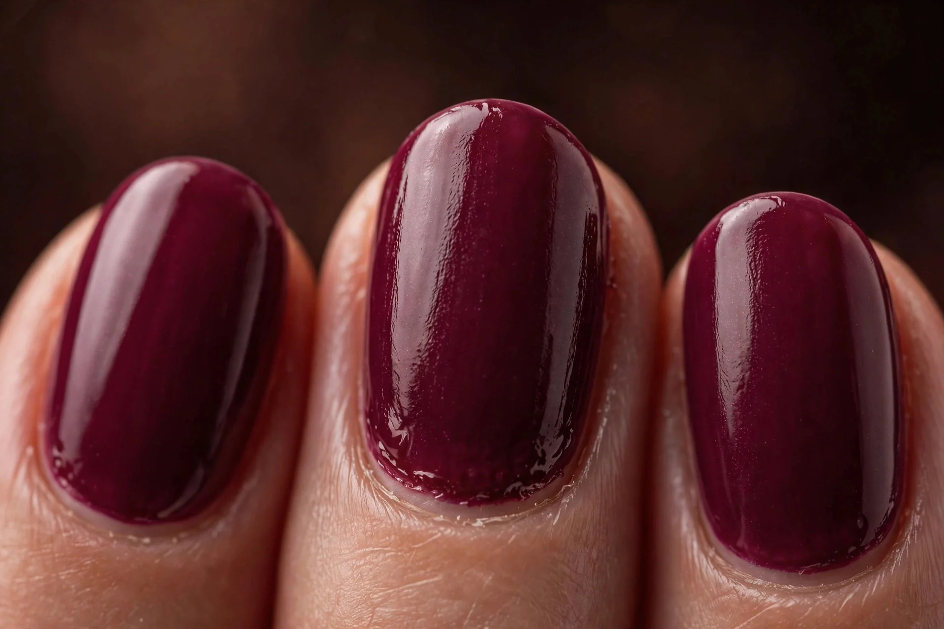 Oval nails in deep berry gel, dark warm background