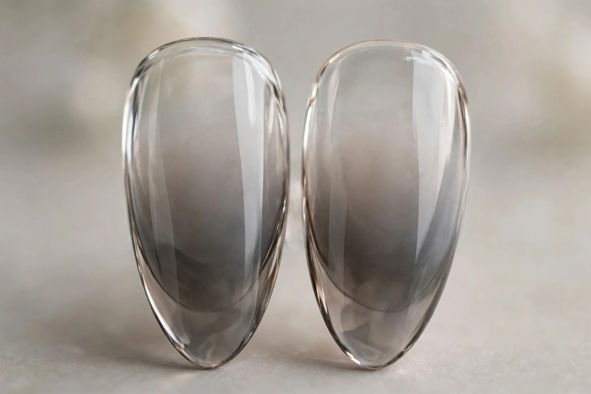 Extreme macro of two almond nails with clear-to-smoky-grey glass ombre gradient, glossy