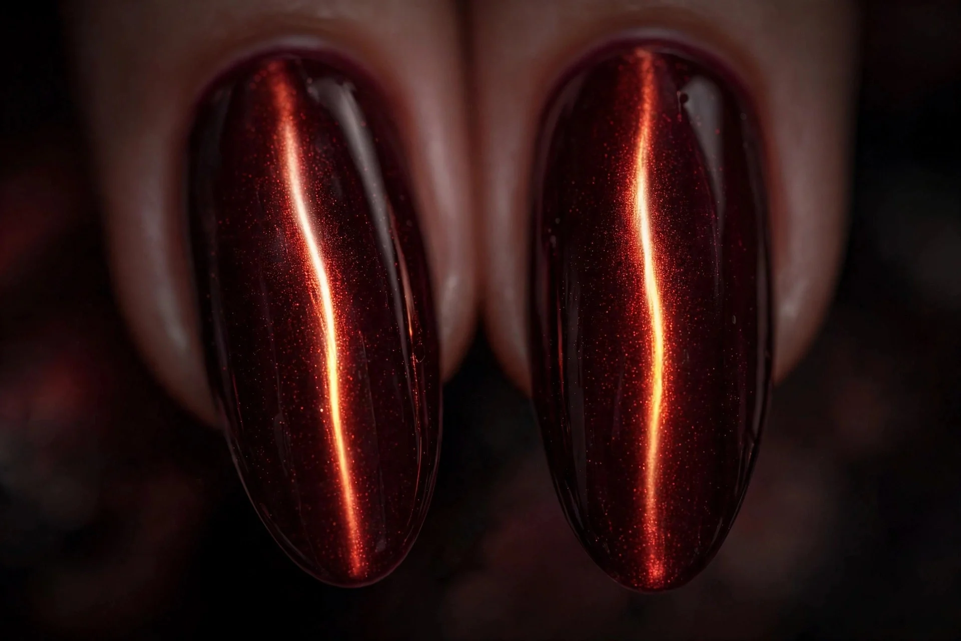 Extreme macro of two long fingernails in burgundy cat-eye gel with a bright intense vertical flame band, vivid dark shine