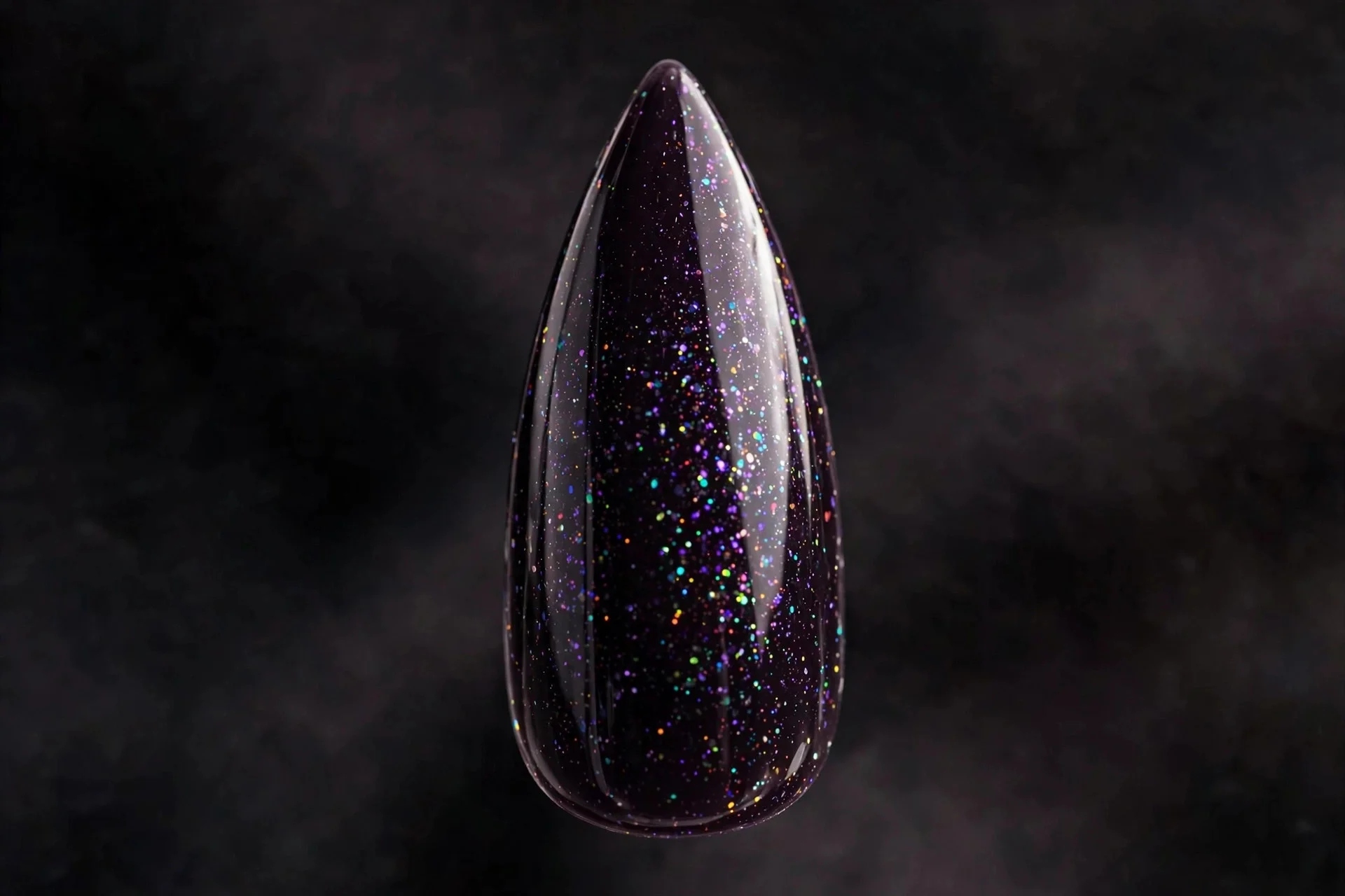 Stiletto fingernail in plum-black chrome with fine holographic sparkle under glossy top coat, dark background