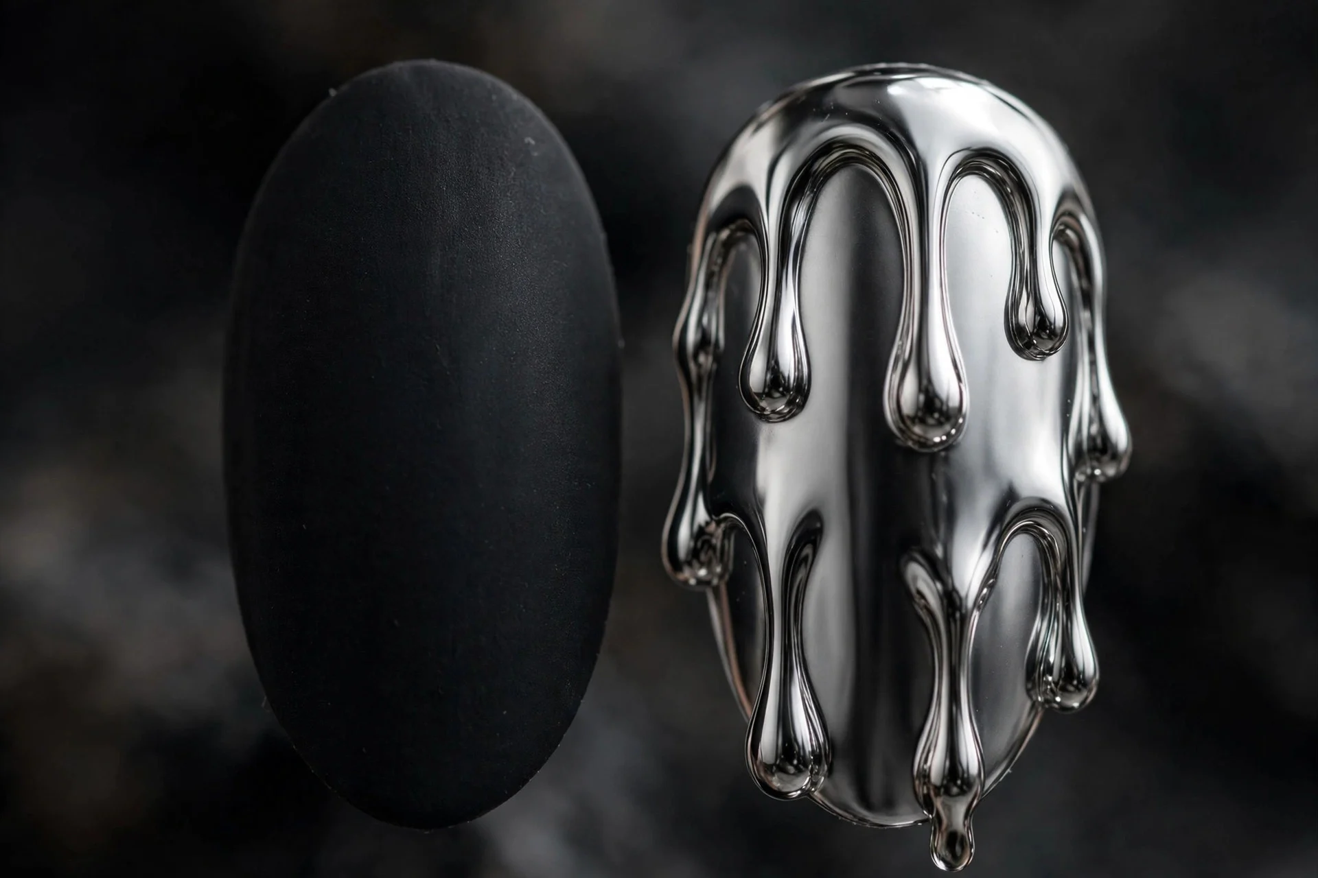 Matte black fingernail beside one nail with molten silver chrome drip design, matte and mirror contrast, dark background
