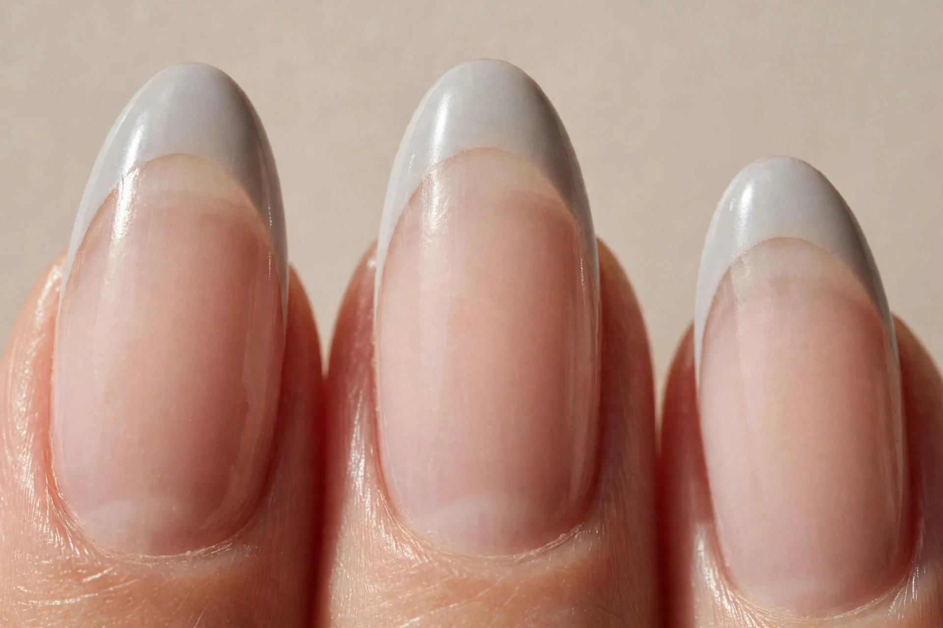 almond nails, sheer nude base, light-grey French tips, glossy