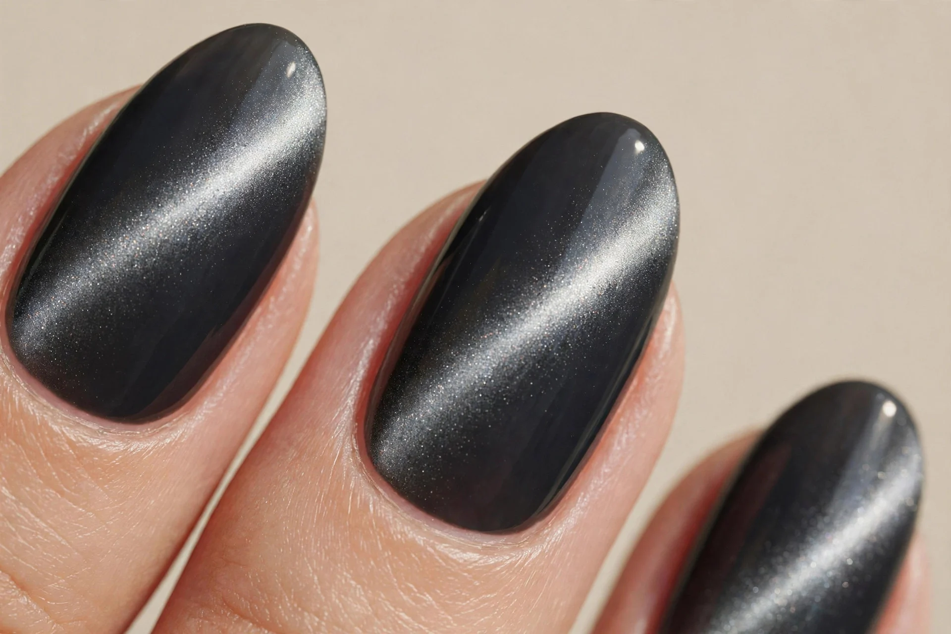 almond nails, deep charcoal base, magnetic silver-grey cat-eye band