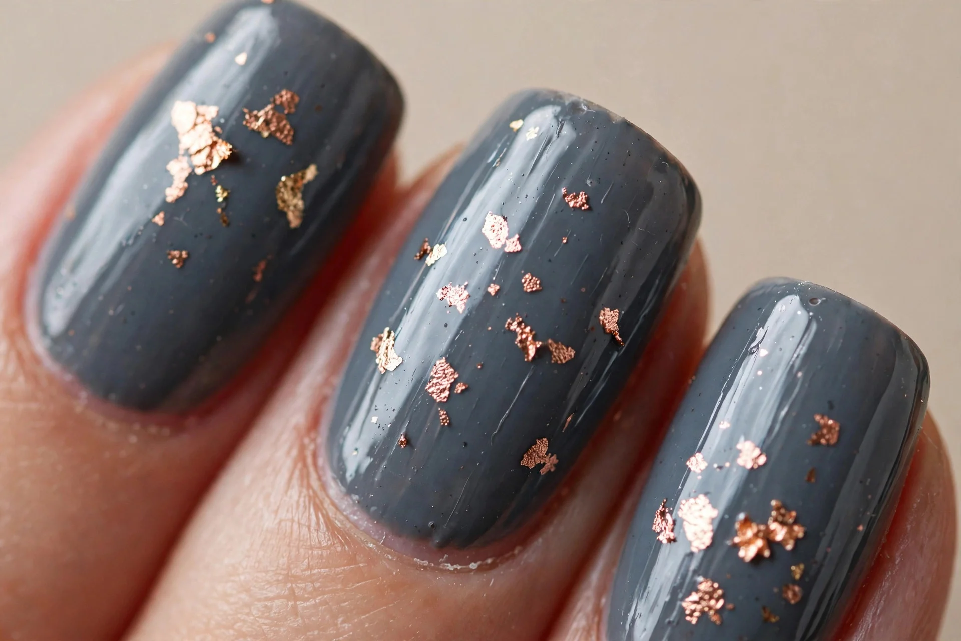 slate-grey nails, scattered rose-gold leaf flakes, glossy