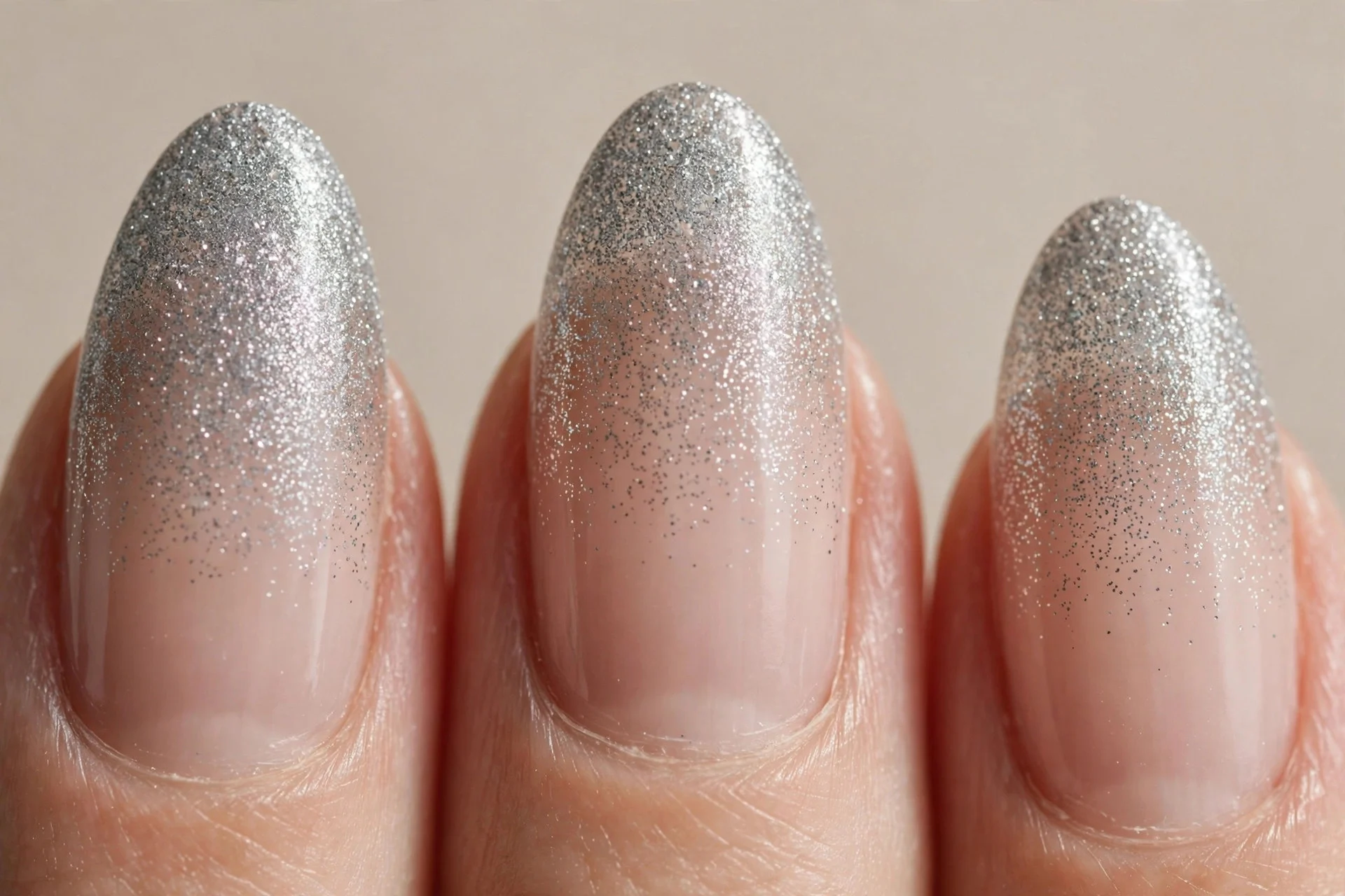 almond nails, silver-grey glitter fading into clear nude base