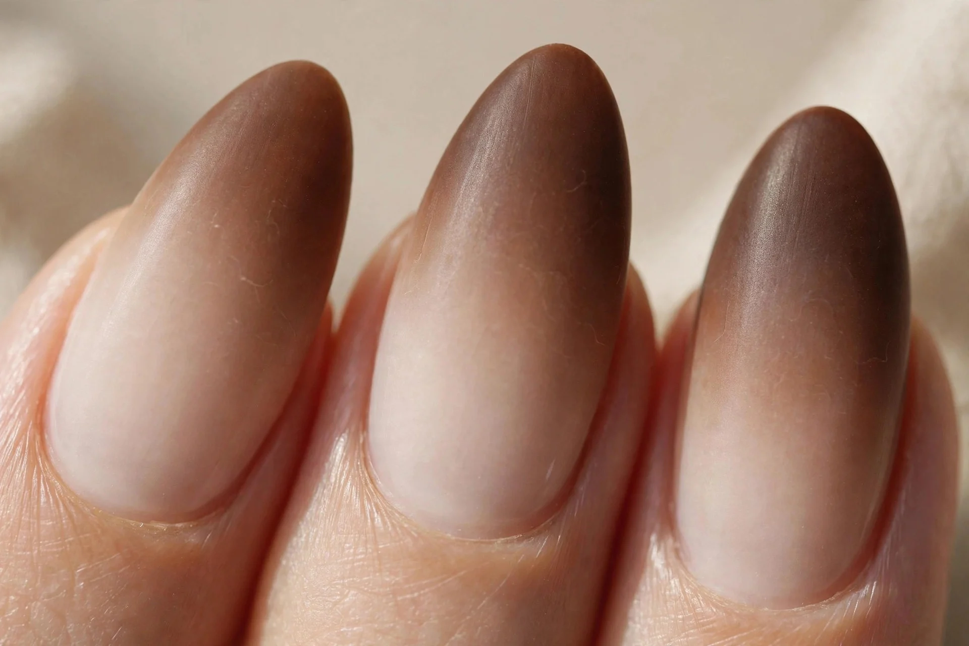 Almond nails with a smooth ombr&eacute; fading from milky beige at the cuticle to coffee brown at the tips.