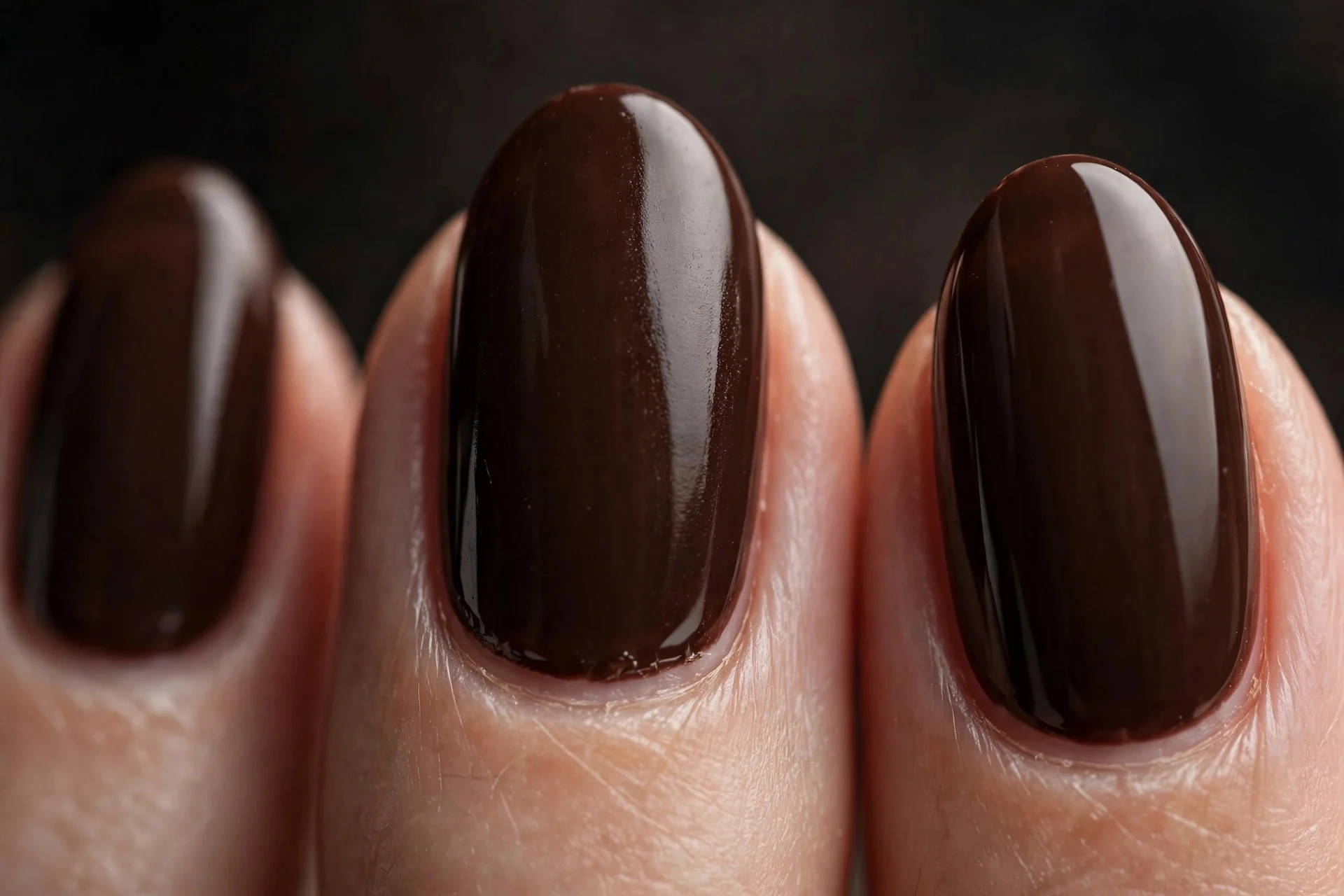 Almond nails in deep espresso brown gel, dark neutral background