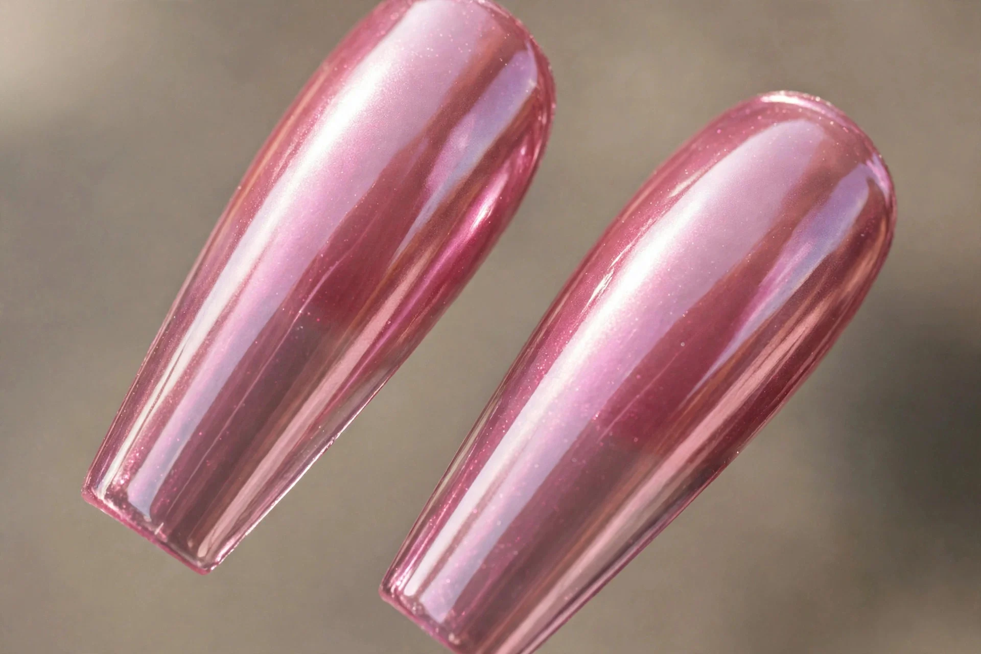 Extreme macro of two long coffin fingernails in jelly pink chrome, dramatic length, high gloss