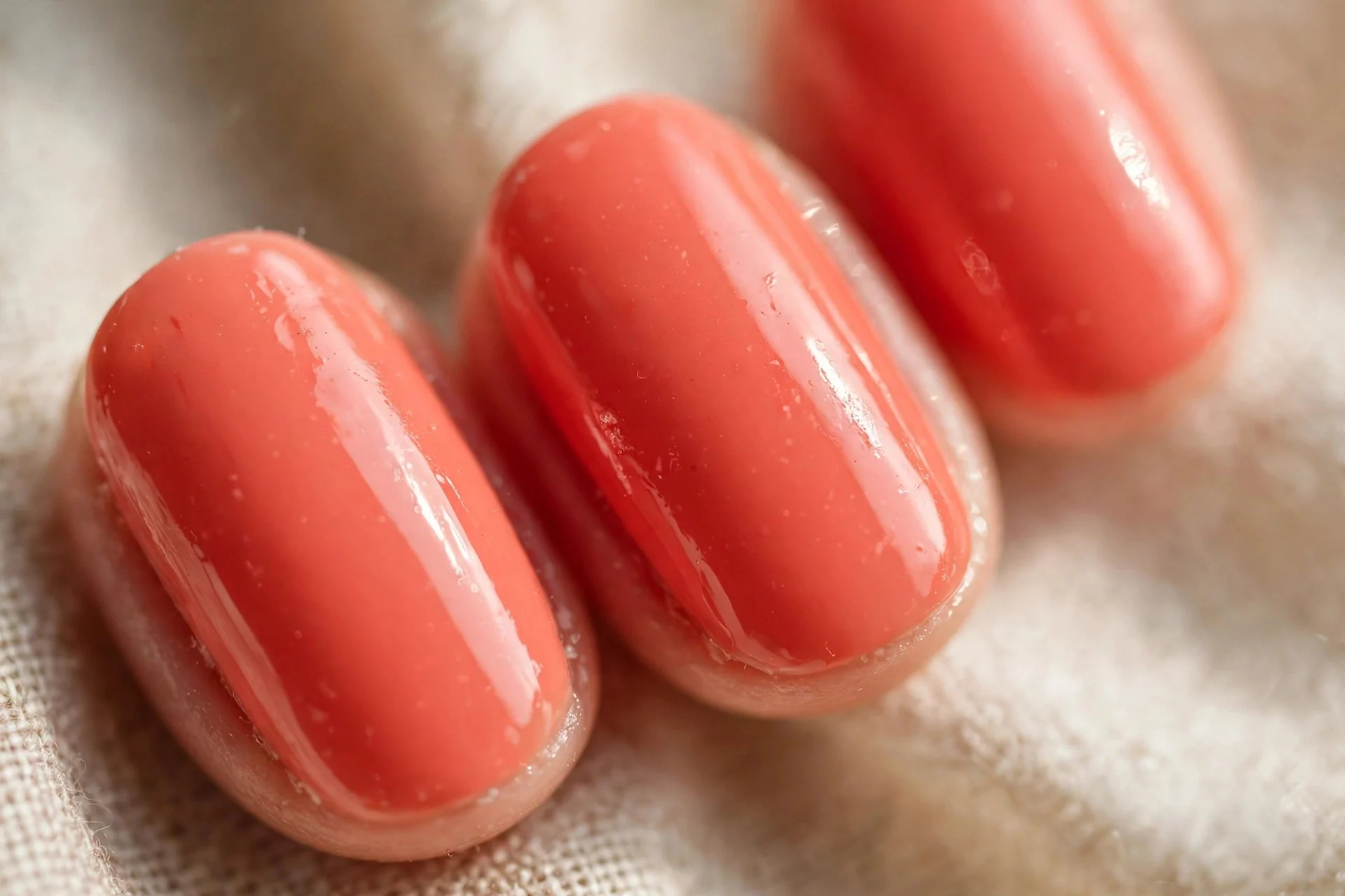 Coral gel manicure done at home, glossy short oval nails