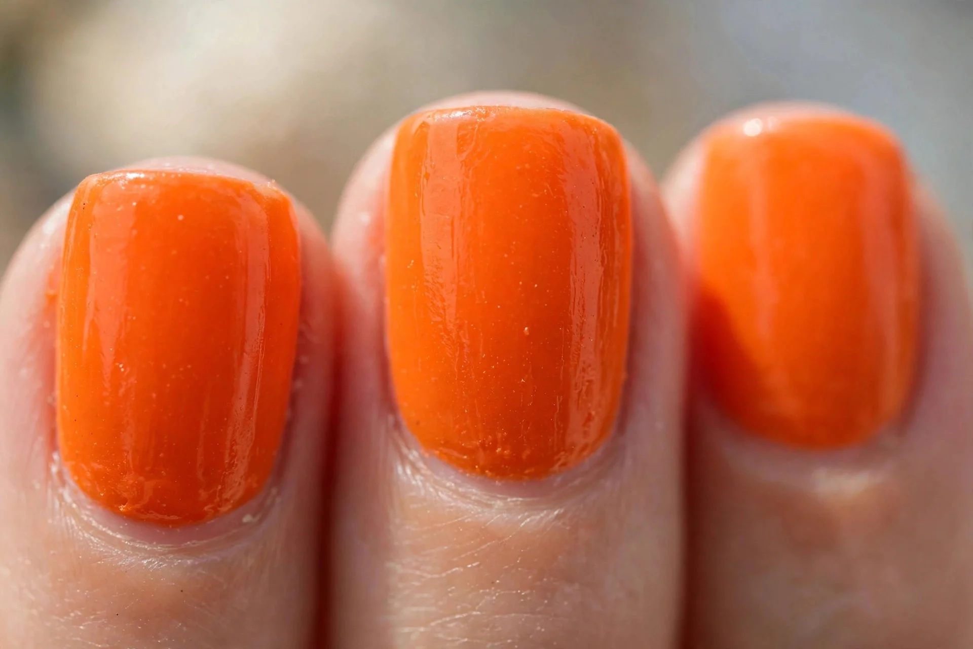 Bright tangerine sorbet polish, short square nails