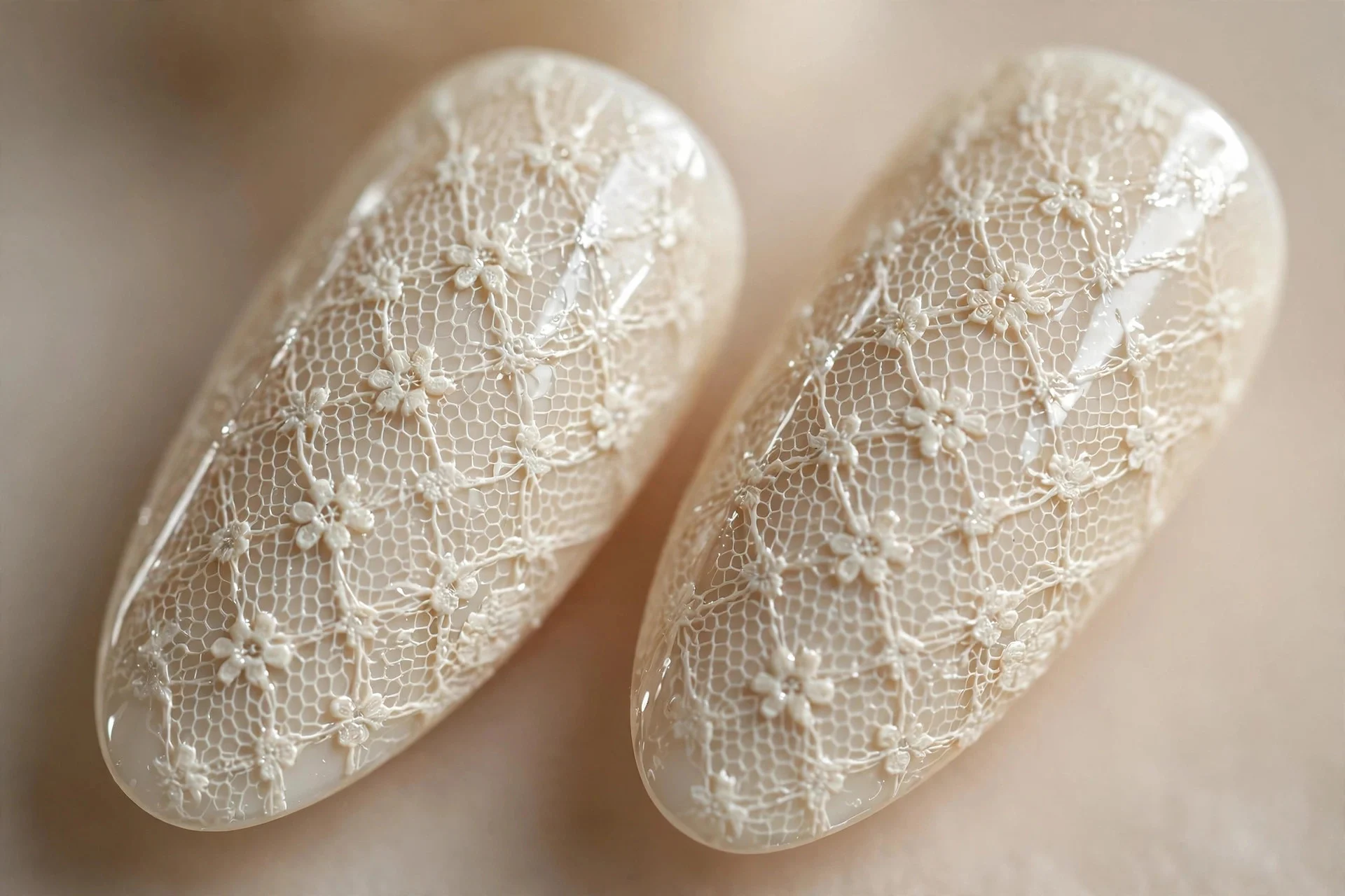 Almond nails with ivory-on-ivory lace stamping over sheer ivory, fine net and floral pattern, glossy, beige background