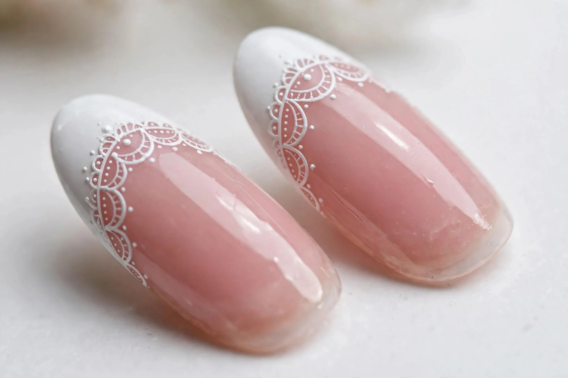 Almond French nails with hand-painted lace scallop edging on white tips, glossy, white background