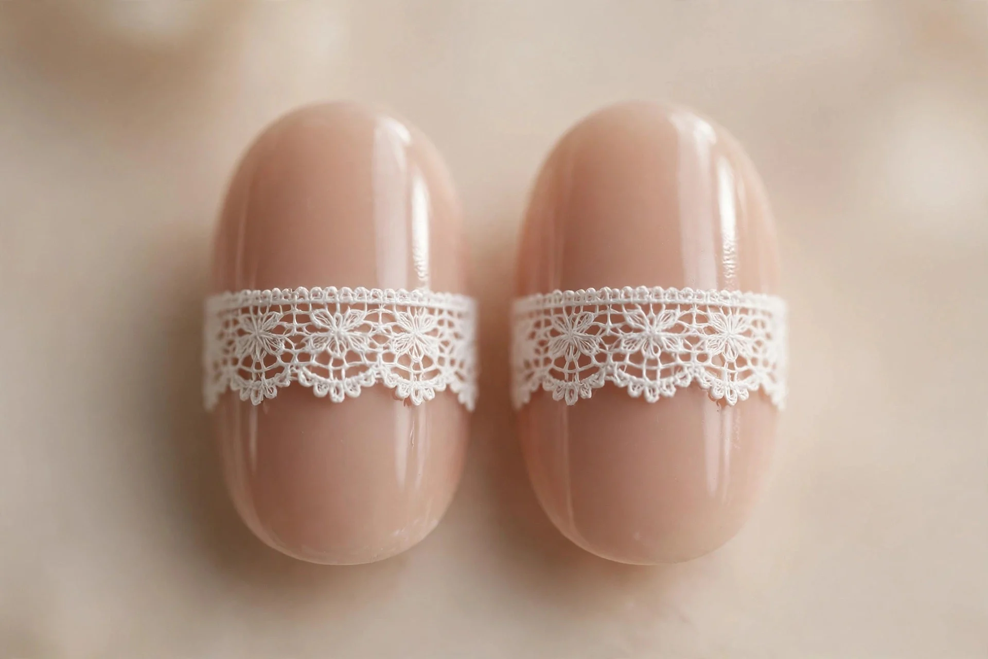 Oval nails with one horizontal white lace band across a nude base, ribbon-hem style, glossy, beige background