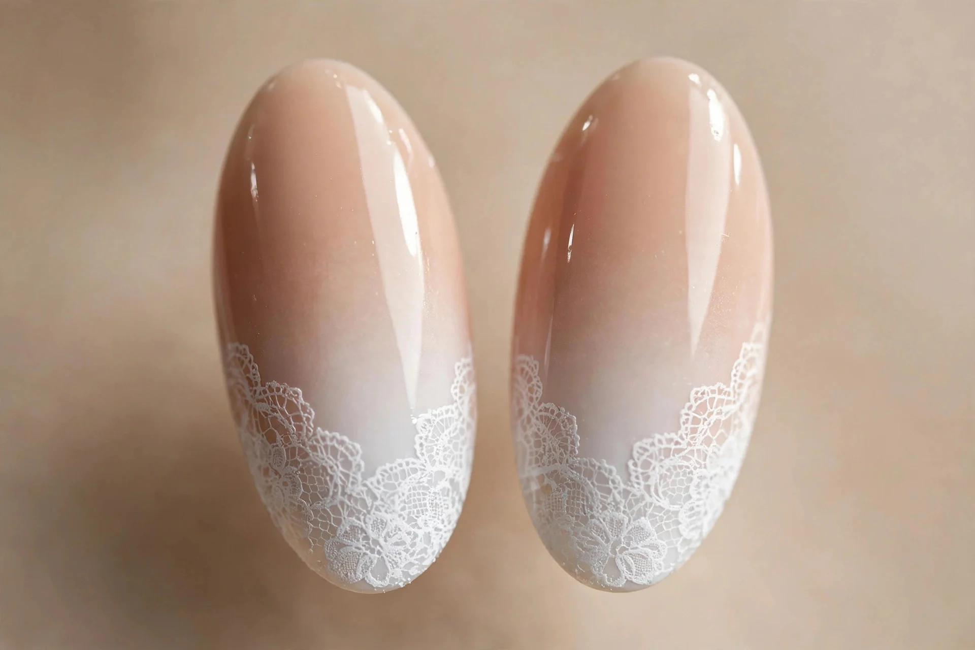 Almond nails with nude-to-white ombre and white lace fading over the lower third, glossy, beige background