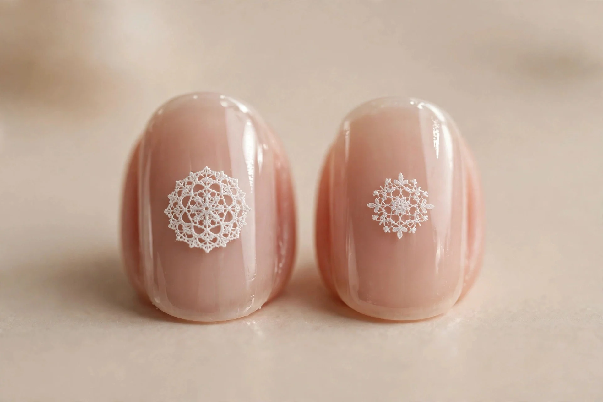 Short rounded nails with tiny white lace medallions over sheer nude, miniature motifs, glossy, beige background