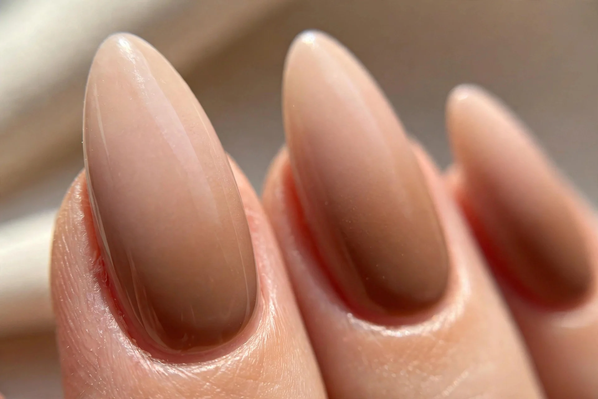 Long almond nails with a nude-to-latte-brown ombre gradient.